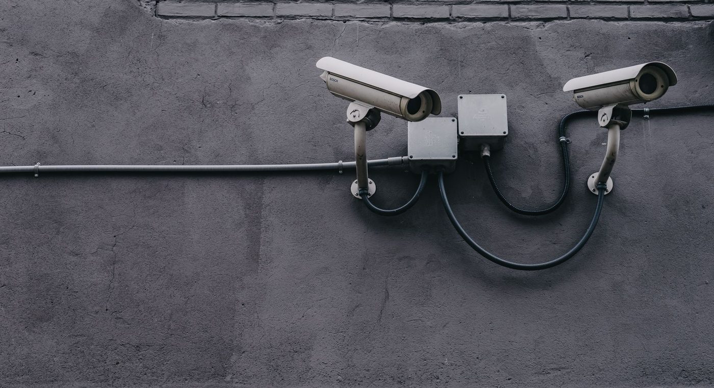 A security camera mounted under the eave of a commercial building