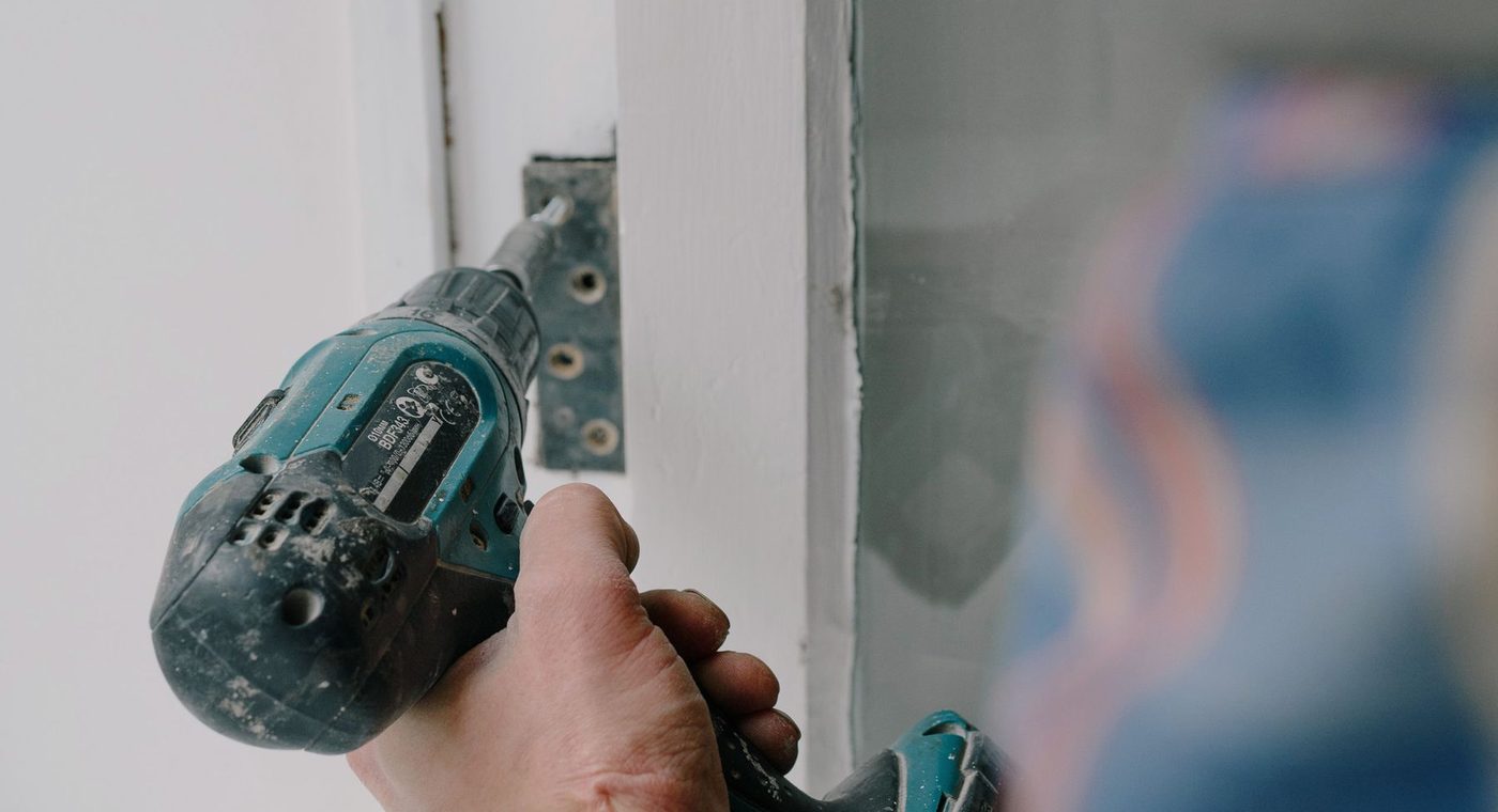 A technician working on the hardware of a commercial door