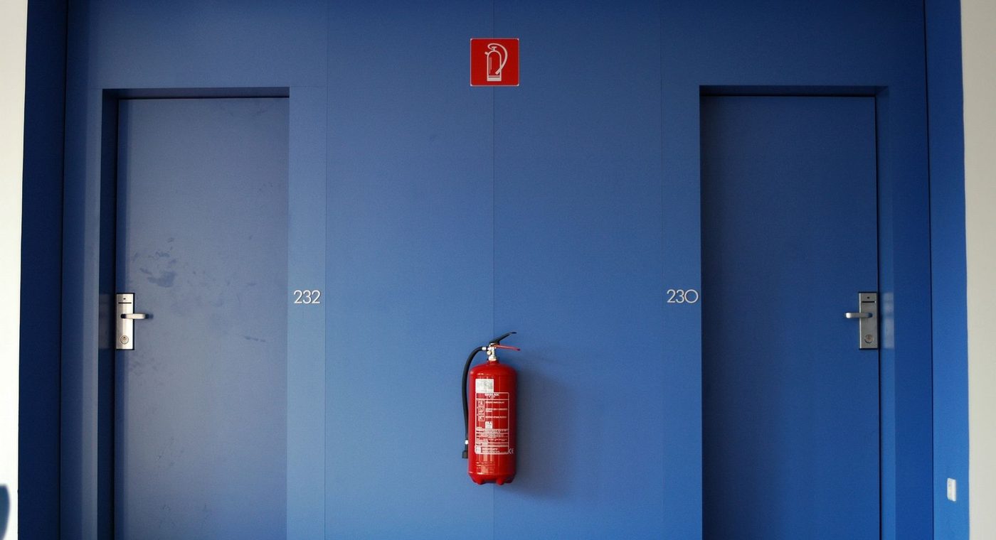 A steel commercial door in a painted metal frame